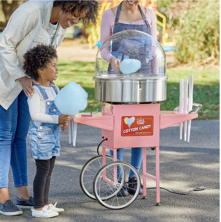 A woman and child looking at cotton candy machine.