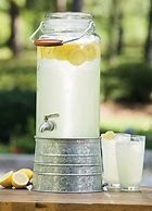 A glass of lemonade with lemons in it.