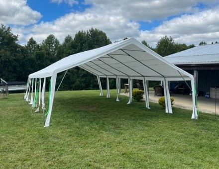 A large white tent in the middle of a field.