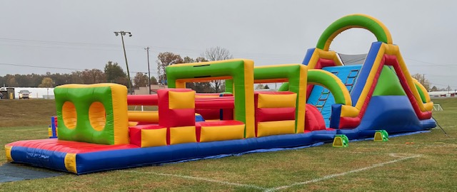 A large inflatable obstacle course set up on the grass.